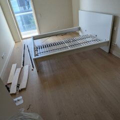 Processo de montagem da cama IKEA, com as peças a serem organizadas.